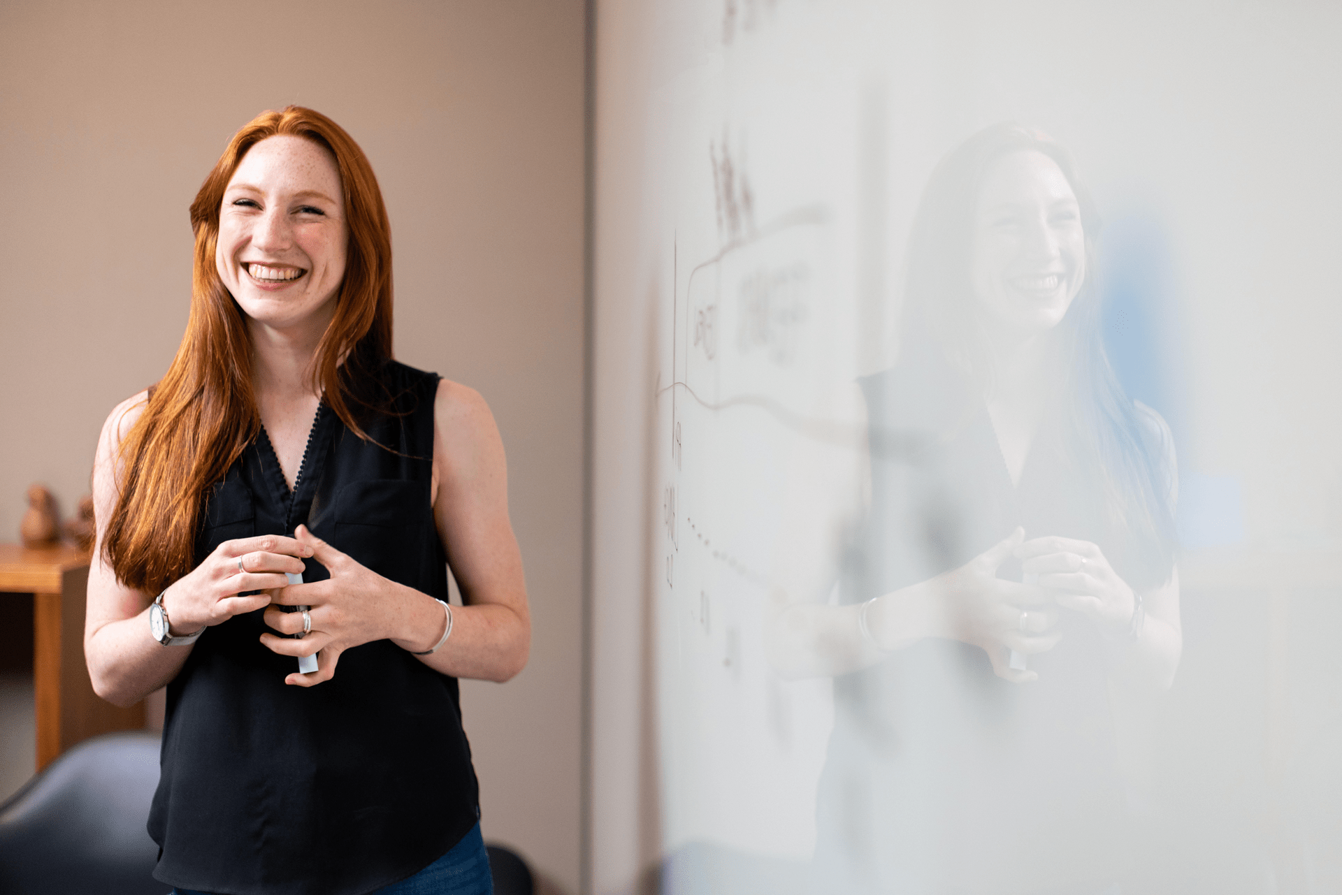A young woman standing next to a dry erase board