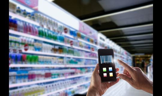 consumer scanning products on smartphone in store