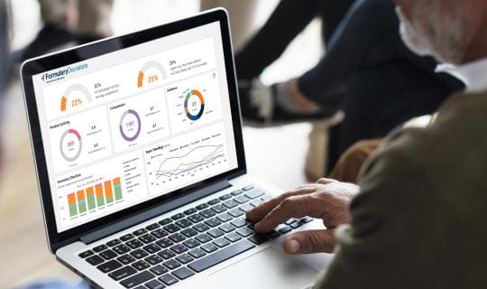businessman with laptop reviewing a dashboard
